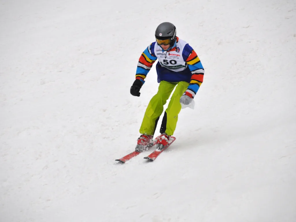 Skifahrer in bunter Jacke auf der Rennstrecke.